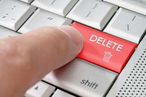 person clicking the delete key on a computer keyboard