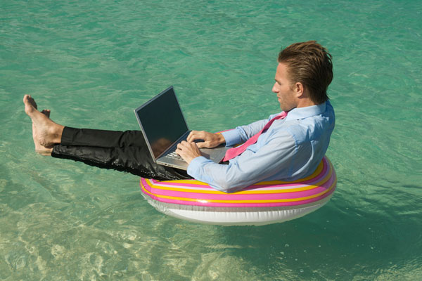 Man working on computer, sitting in inner tube