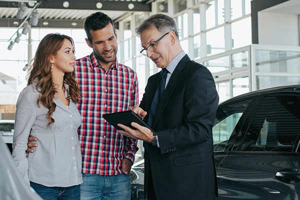 Couple reviewing tablet with salesperson