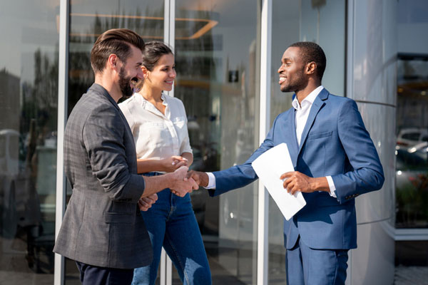 Salesperson shaking couple's hands