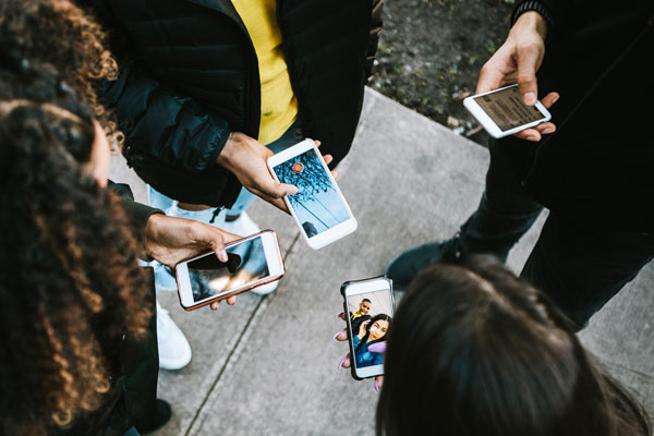 Young people holding mobile phones in a circle