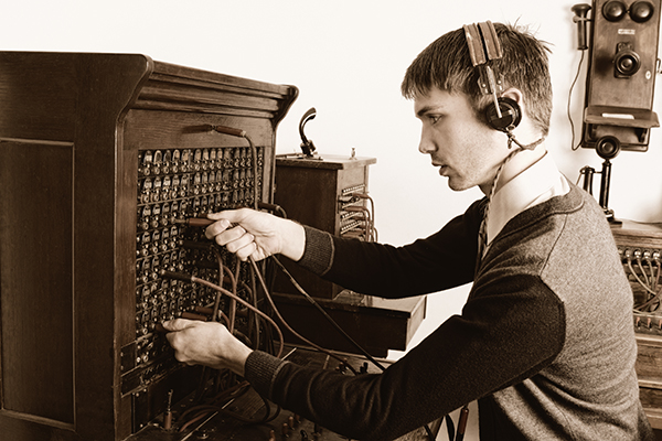 Telephone operator using antique switchboard
