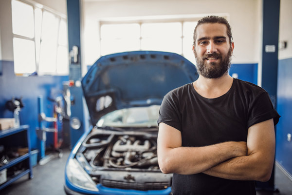 Man standing in front of vehicle with open hood