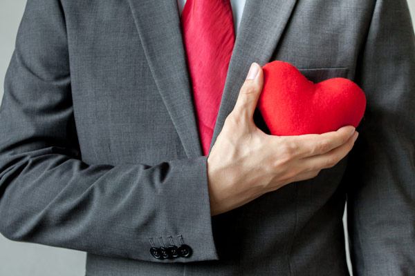 Man in suit holding plush heart