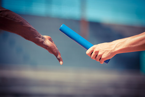 Two runners passing off baton