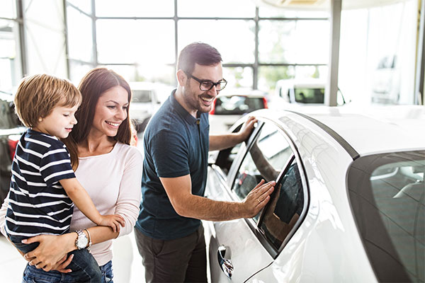 Couple with young child shopping for a vehicle