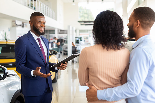 car salesman working with a couple