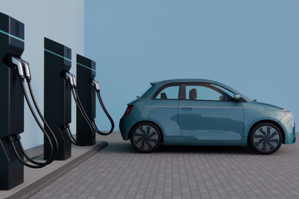 Blue smart car charging at an electric charging station.