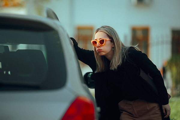 Person looking defeated into a vehicles side window.